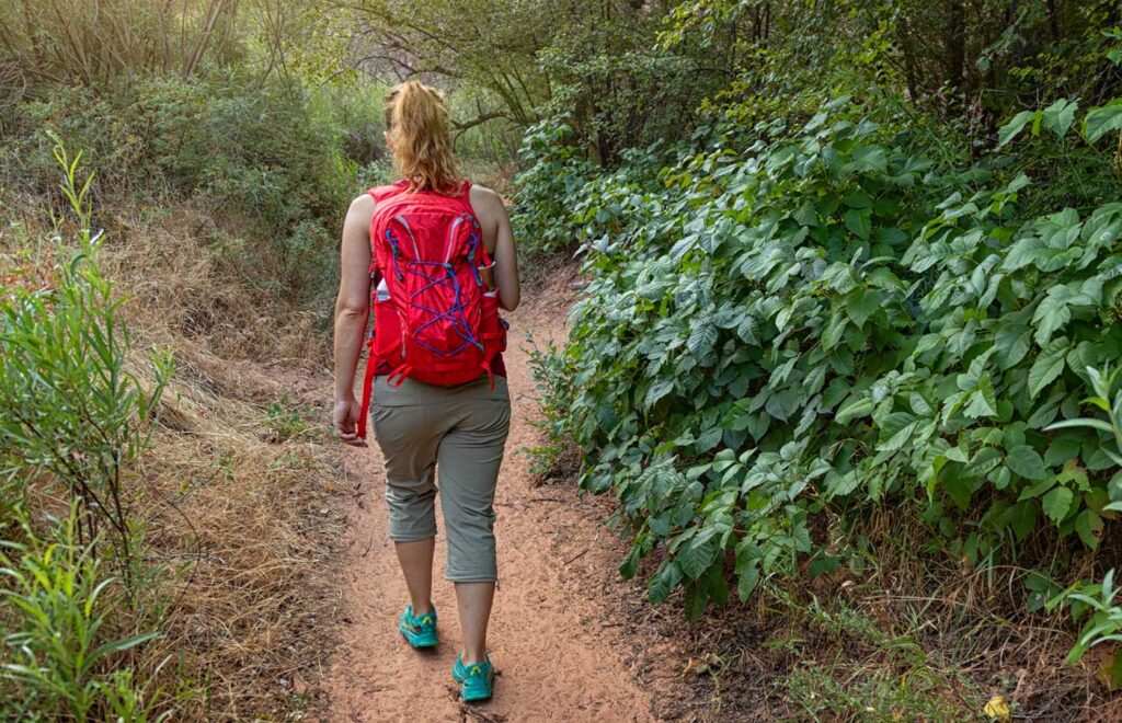 Woman hiking near a patch of poison ivy
