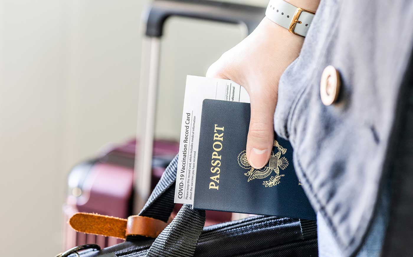 Traveler holding passport and COVID documentation